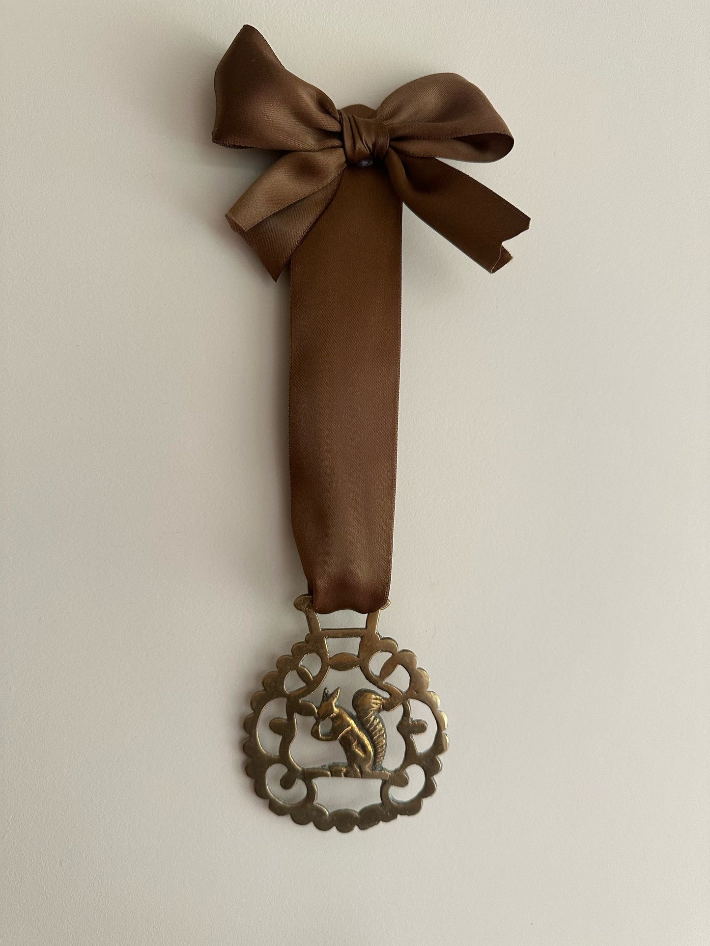 vintage brass token on bow ribbon