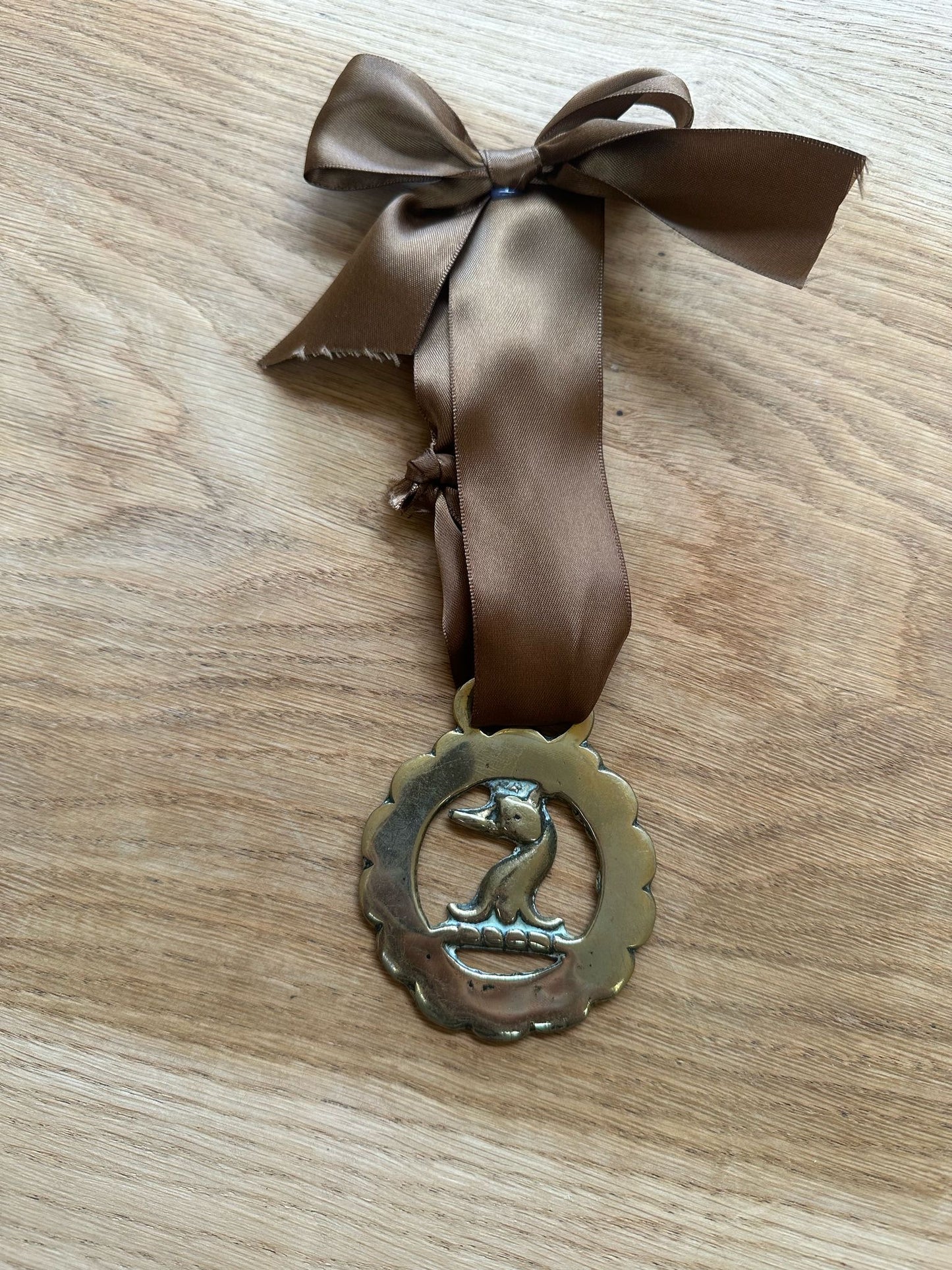 vintage brass token on bow ribbon