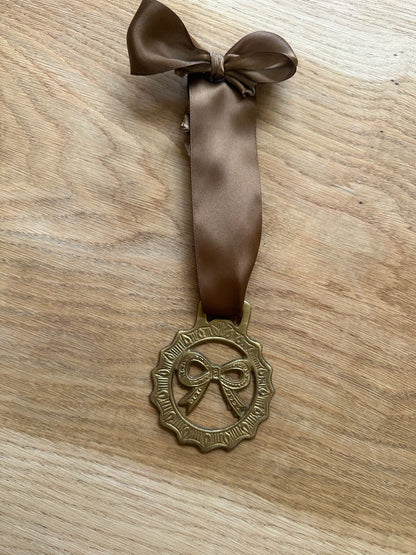 vintage brass token on bow ribbon